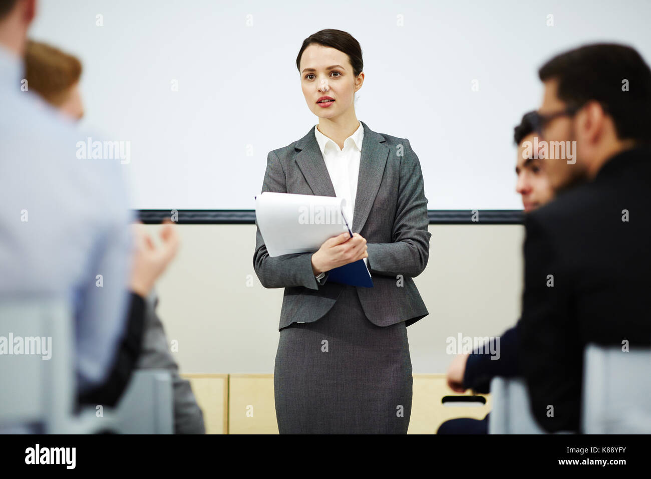 Giovane insegnante ascoltando le opinioni e le idee dei suoi studenti dopo la lezione Foto Stock