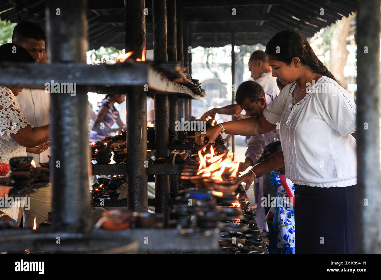 Kandy, Sri lanka - Gennaio 4, 2017: persone accendendo candele per preghiere al di fuori del tempio del Dente a Kandy city, sri lanka Foto Stock