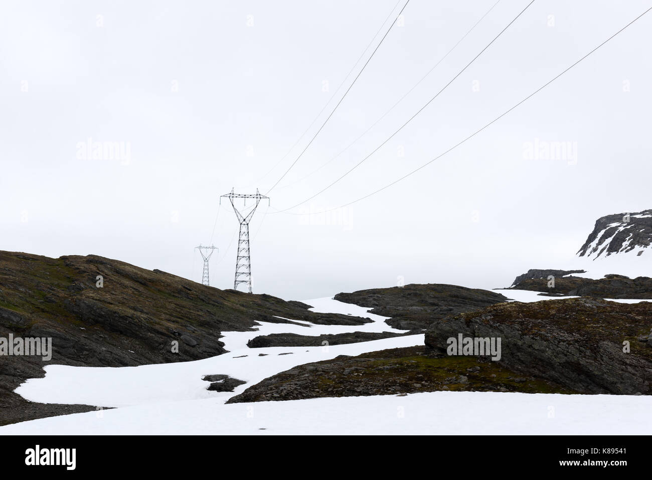 Tipico paesaggio norvegese con montagne innevate e linea elettrica vicino alla famosa aurlandsvegen (bjorgavegen), strada di montagna, Aurland, Norvegia. Foto Stock