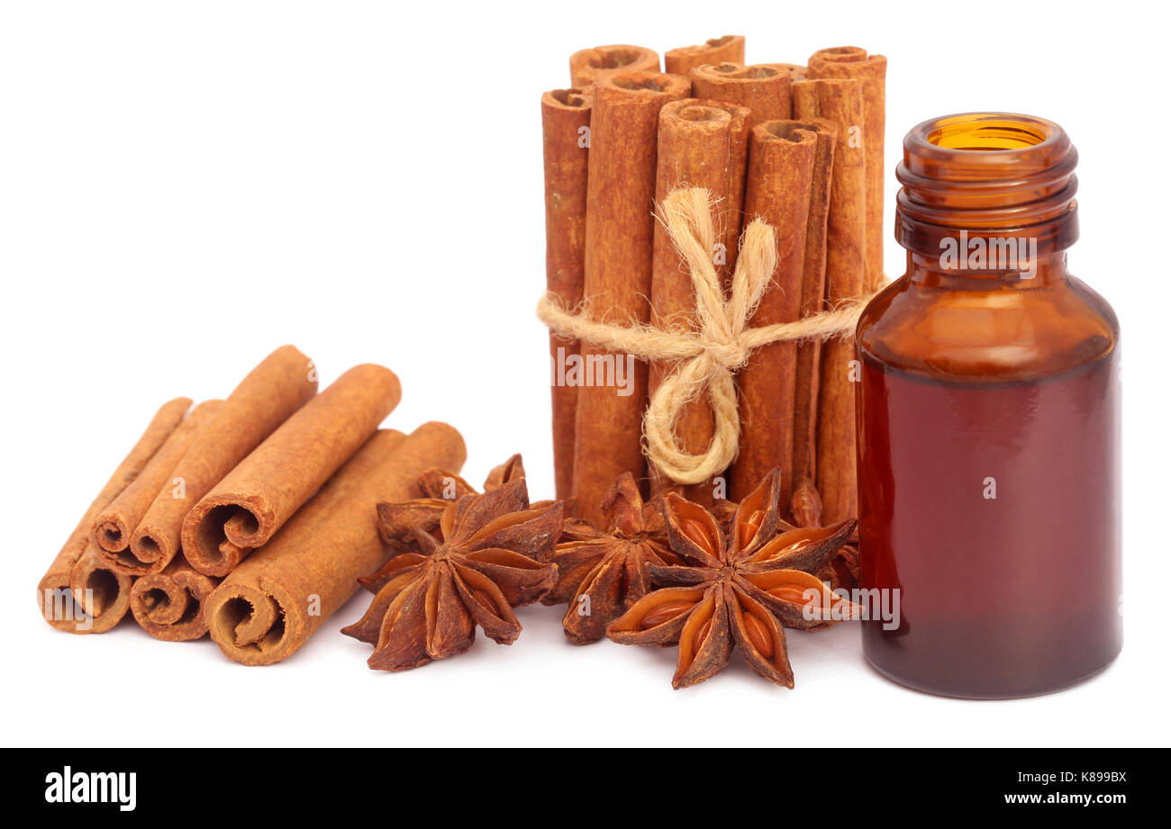 Alcuni cannella aromatica con anice stellato e olio essenziale in una bottiglia Foto Stock