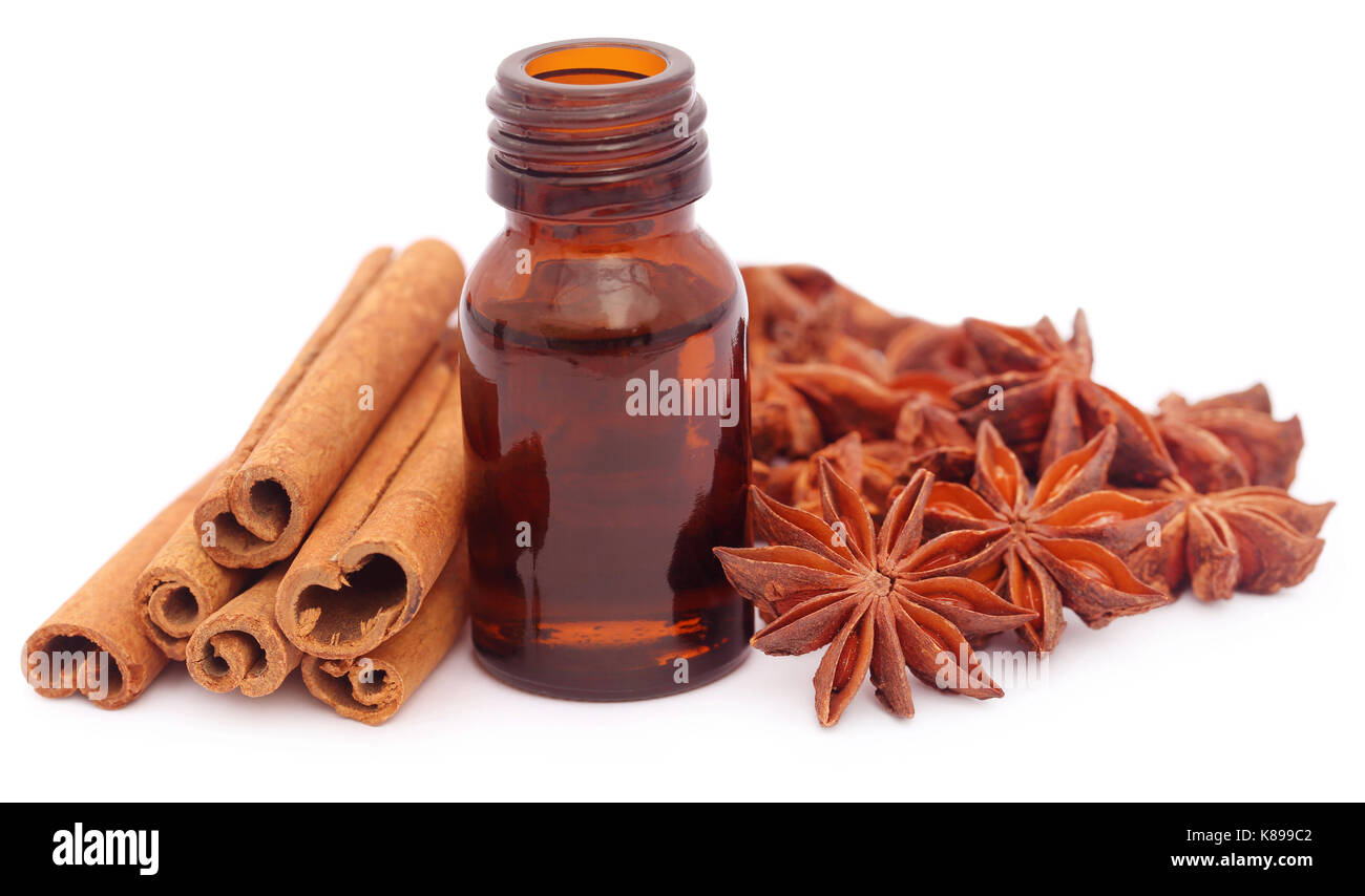 Alcuni cannella aromatica con anice stellato e olio essenziale in una bottiglia Foto Stock