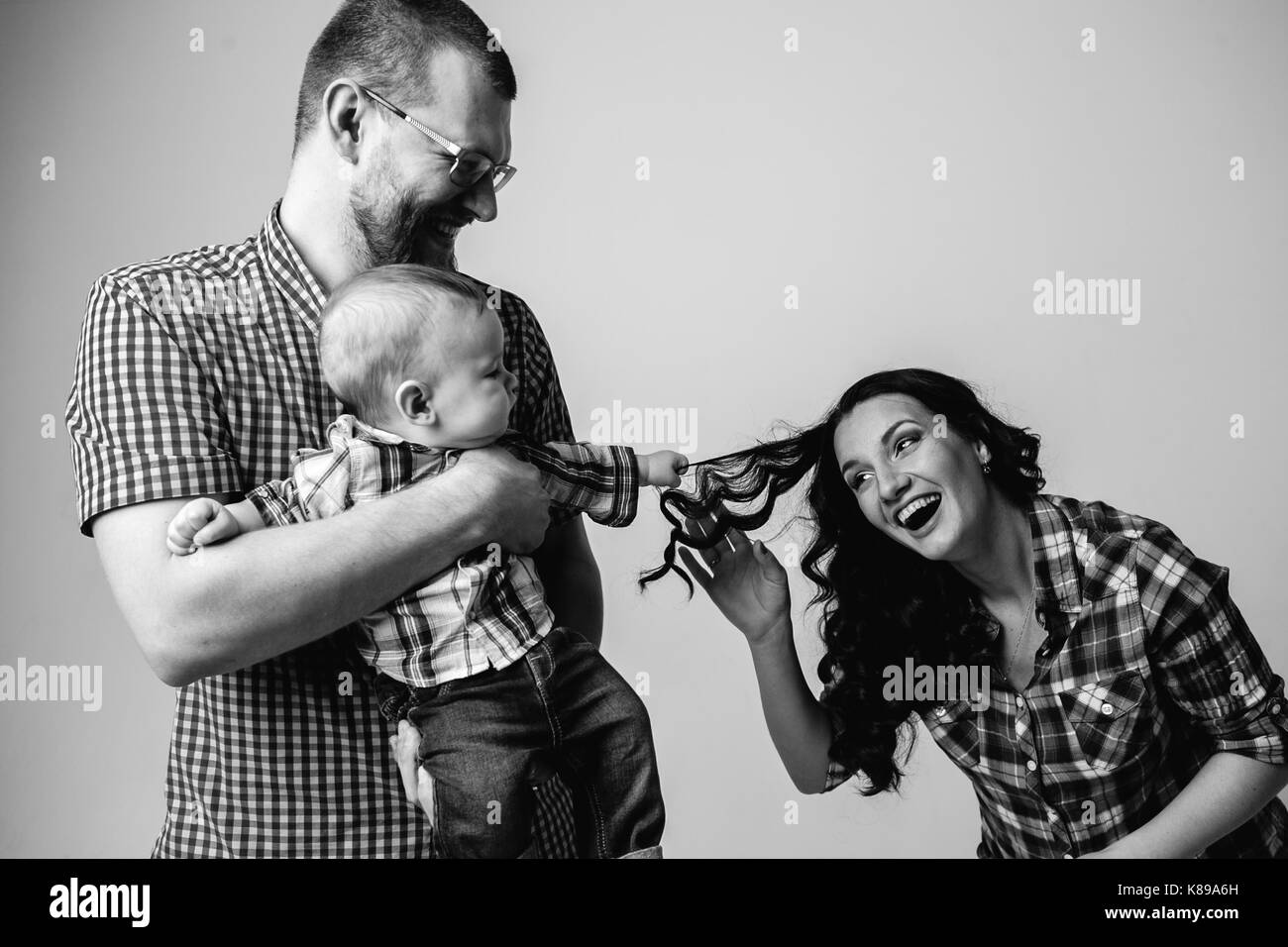 Gioiosa i genitori e il bambino ridere e giocare Foto Stock