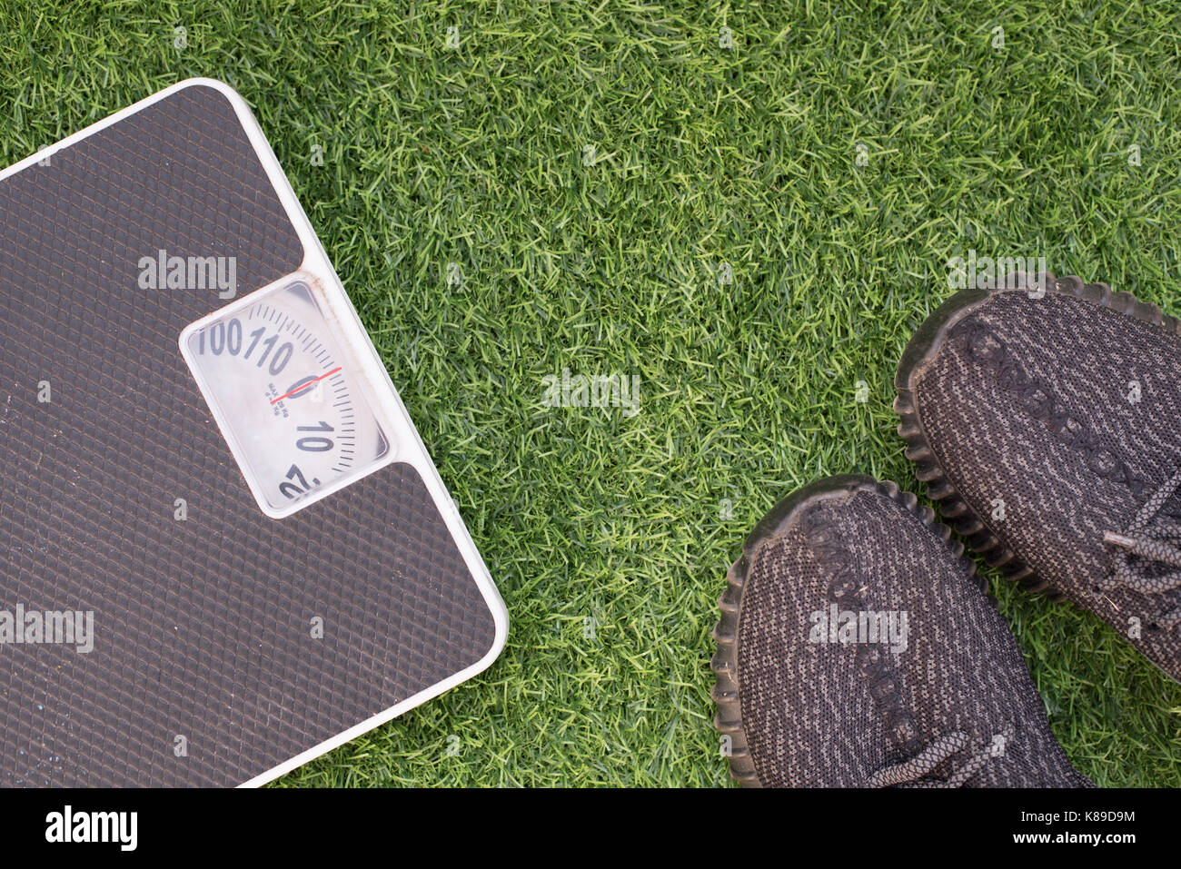 Fitness e perdita di peso concetto, scala bianco e scarpa sportiva su erba, vista superiore, libera spazio di copia Foto Stock