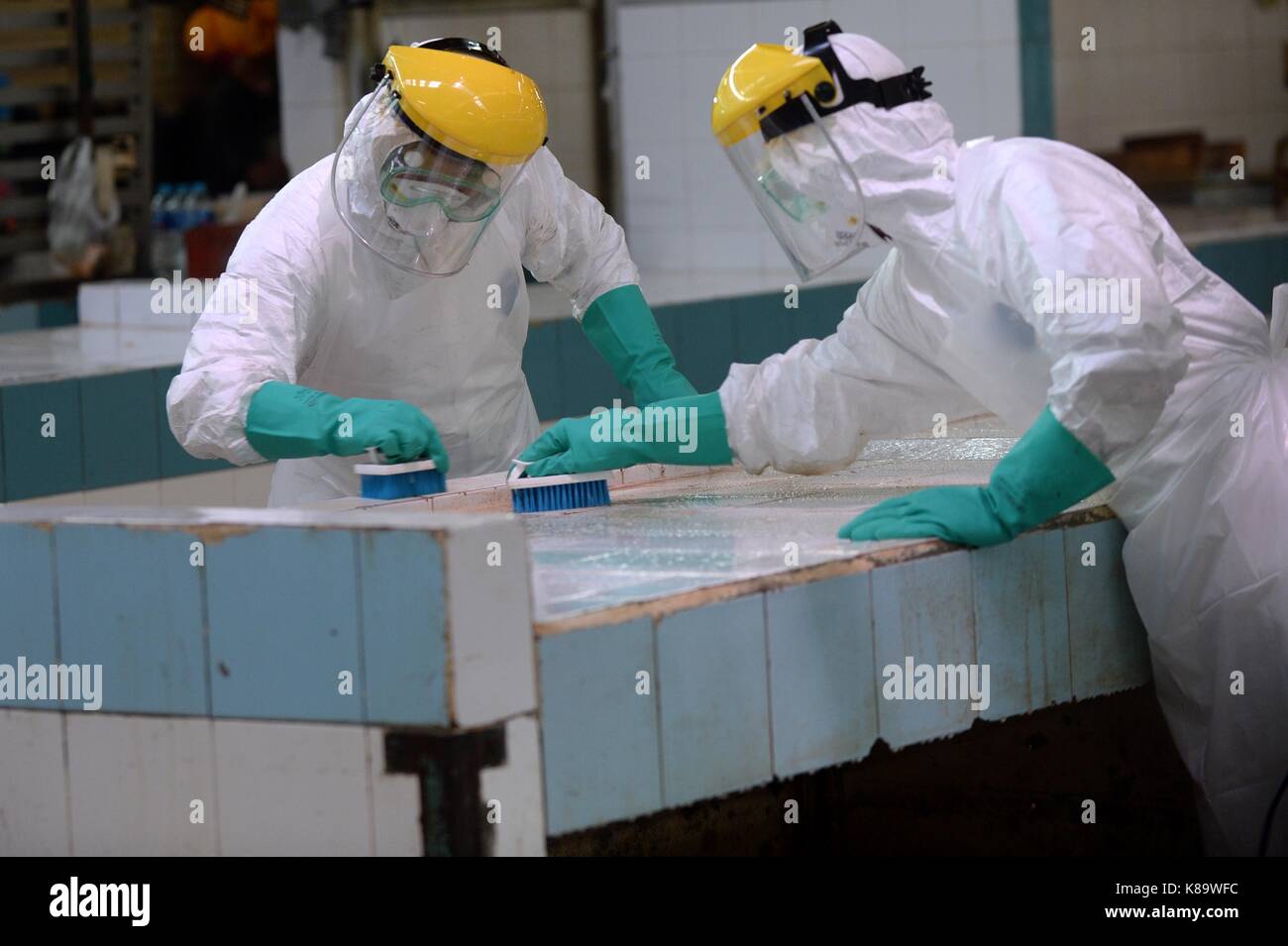 Sud tangerang. Xix Sep, 2017. Funzionari indossando maschere e tute di protezione pulire un pollo in stallo durante la pandemia influenzale trapano di risposta in un mercato nel sud tangerang, Indonesia. sept. 19, 2017. Credito: agung kuncahya b./xinhua/alamy live news Foto Stock