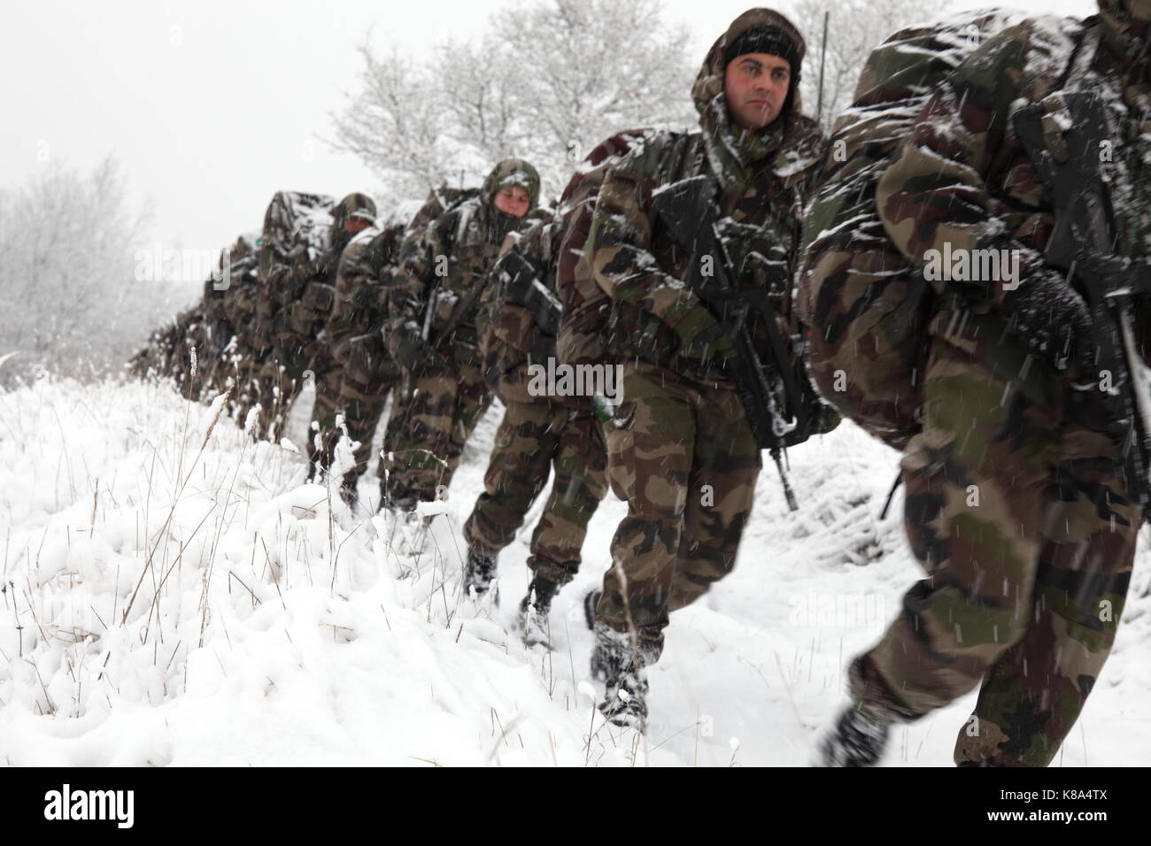 Legione Straniera francese reclute (Engagé Volontaires) a piedi attraverso derive di neve e blizzard condizioni mentre il loro 'Kepi marzo " vicino al 4REI, 2CIE's Foto Stock