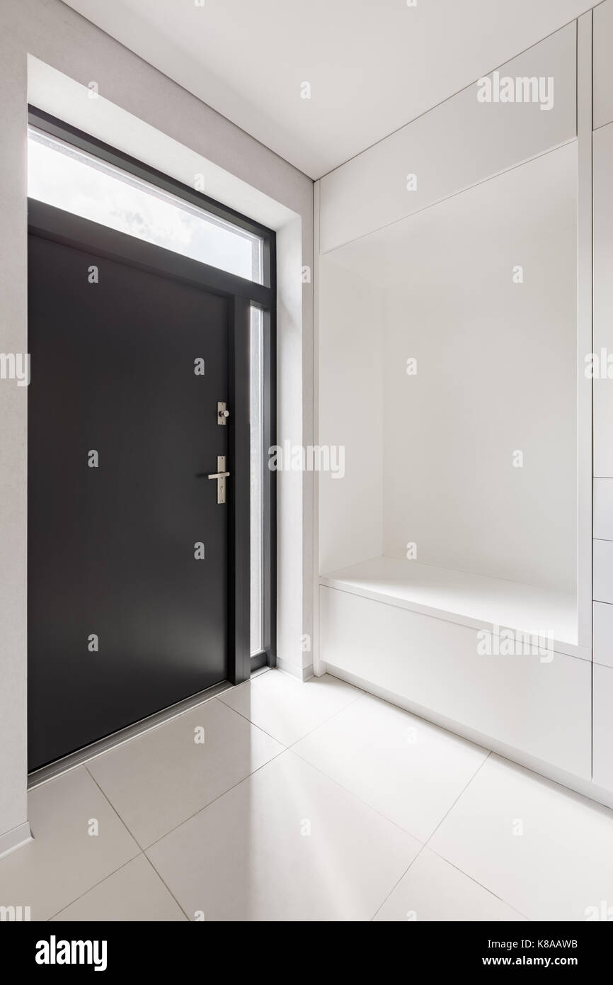 Elegante arredamento bianco con ingresso e porta nera Foto Stock