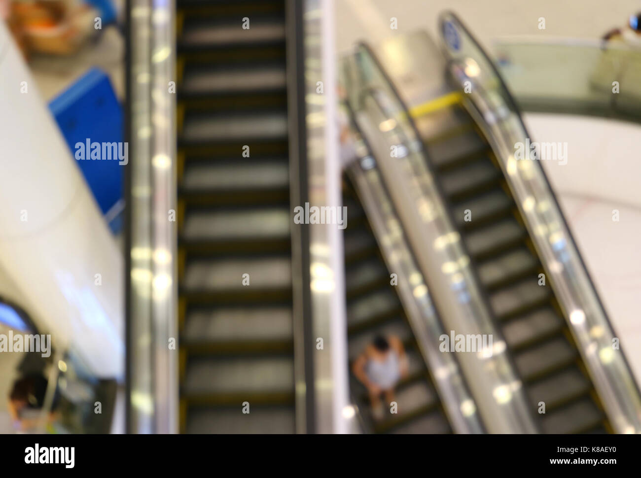 Abstract sfocato delle scale mobili con persone di andare verso il basso in un centro commerciale per lo shopping Foto Stock