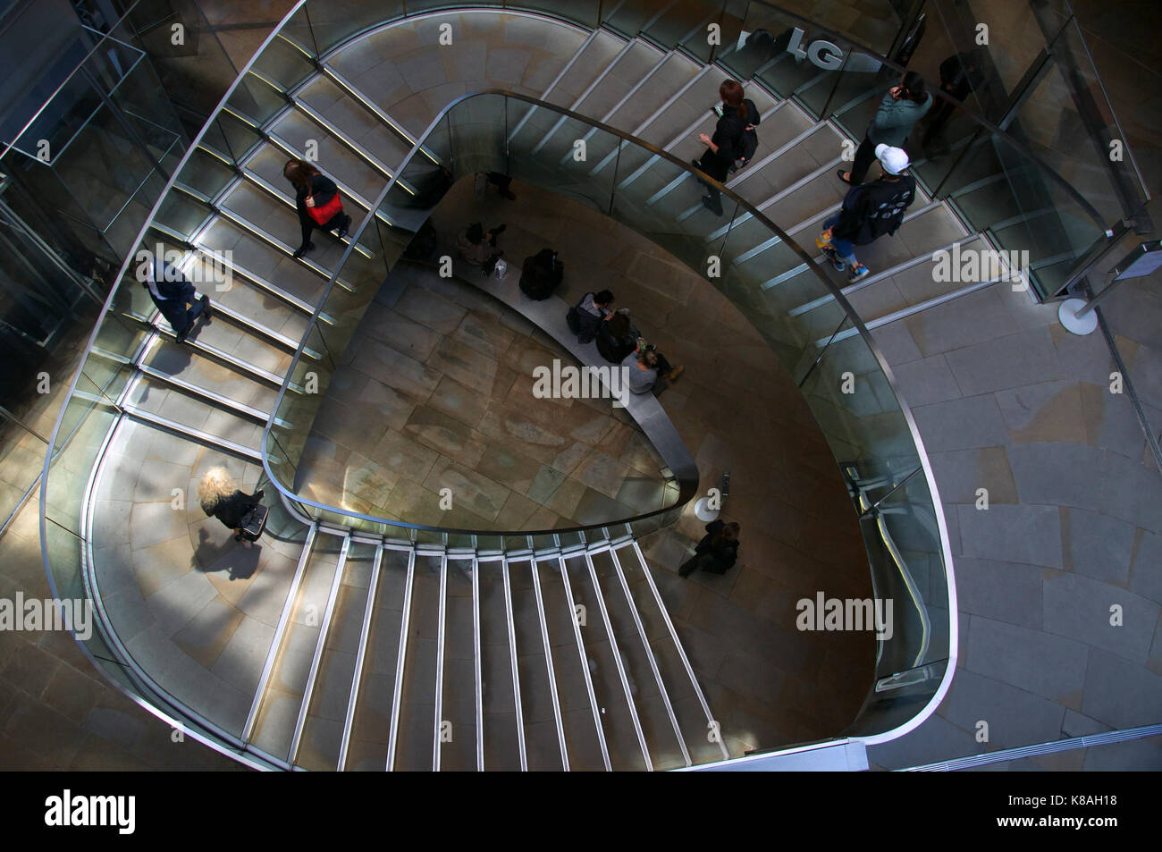 Triangolare arrotondata scala con gente che va su e giù Foto Stock