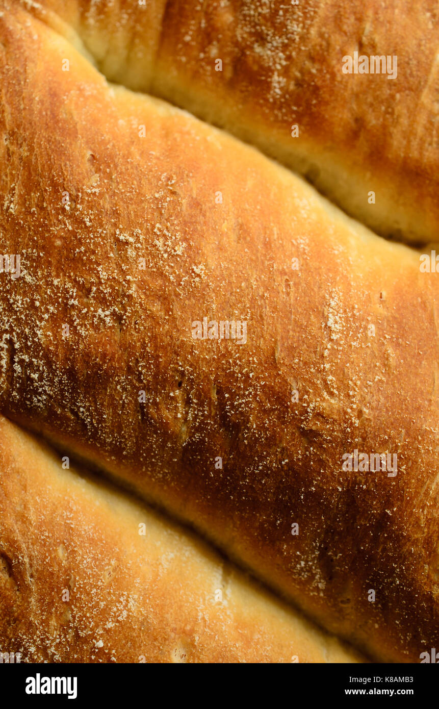 Close up (macro) del golden brown crosta di pane appena sfornato pagnotta di pane bianco. Foto Stock