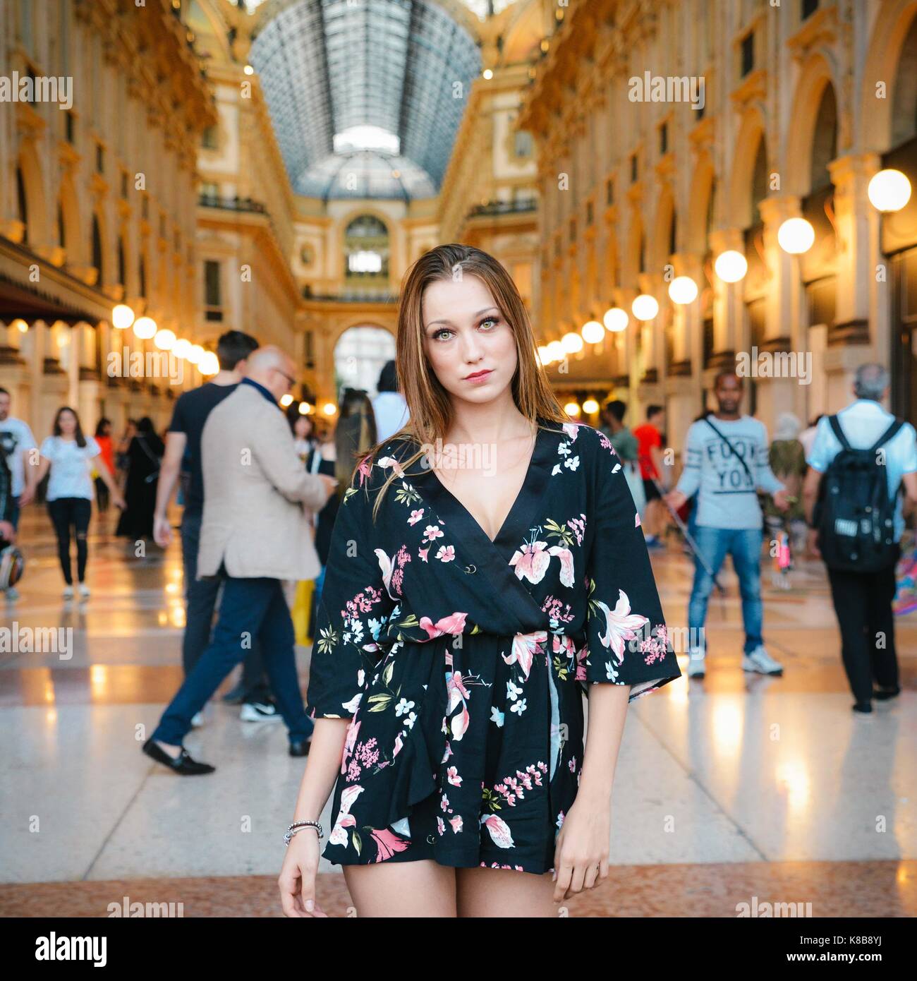Attraente donna italiana (20-22) pone di fronte a Vittorio Emanuele II a Milano Milano è la capitale mondiale della moda Foto Stock