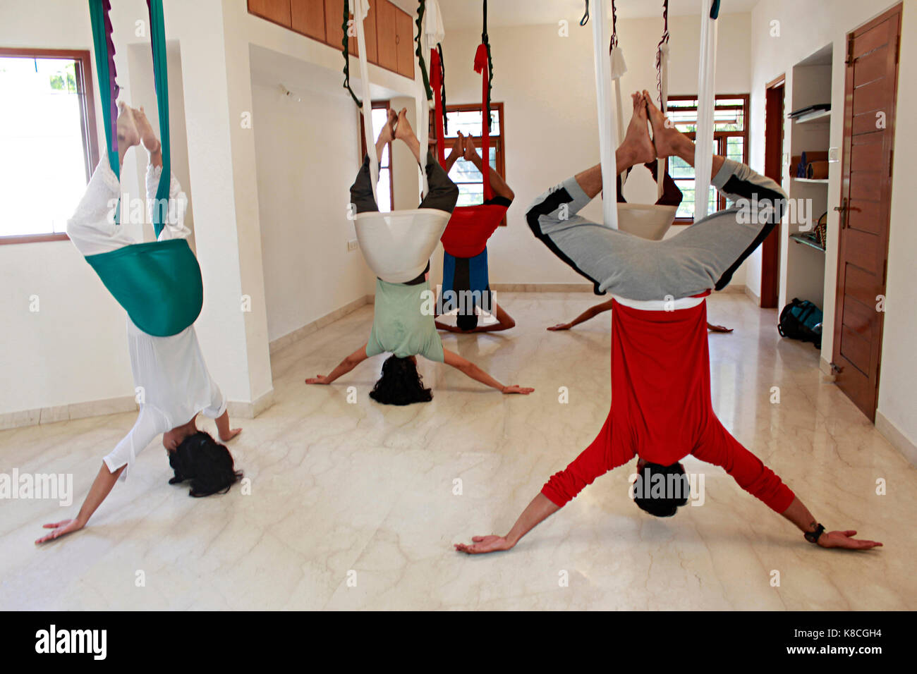 Un' antenna yoga classe praticare supta baddha konasana Foto Stock