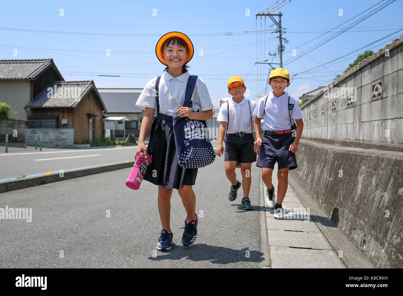 Scuola elementare ragazza camminare sulla strada Foto Stock