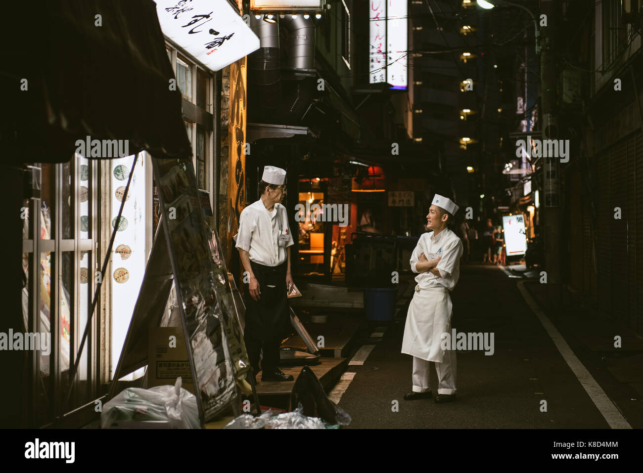 Chef di sushi prendendo una pausa la sera presso il mercato del pesce di Tsukiji, Tokyo, Giappone. Foto Stock