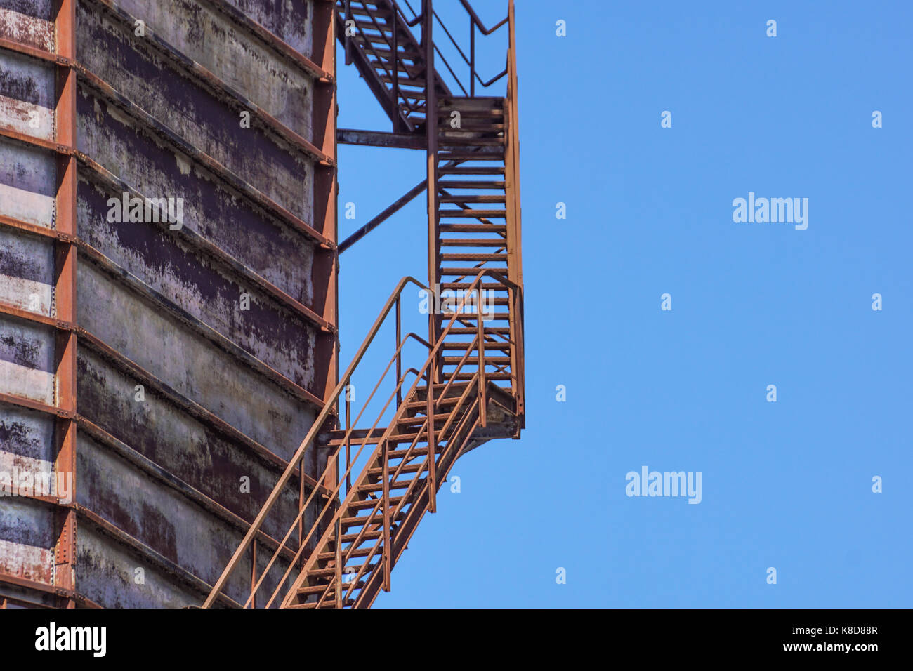 Calcestruzzo industriale cilindrico silo con scale di metallo con ringhiera di sicurezza e grandi tubi di diametro interno. Foto Stock