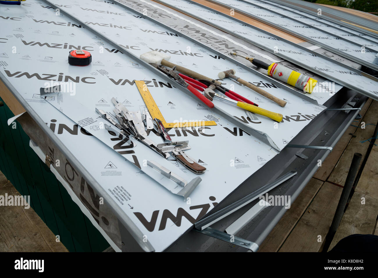 Tetto di zinco essendo realizzati in un nuovo edificio con tetto curvo. Foto Stock