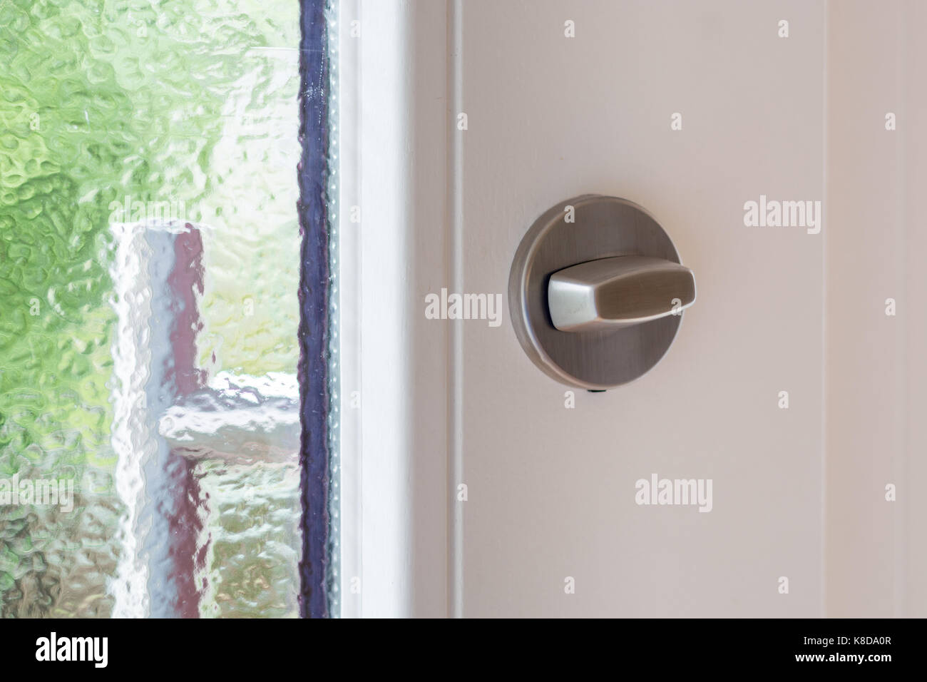 Un blocco di metallo su bianco porta in legno close up Foto Stock