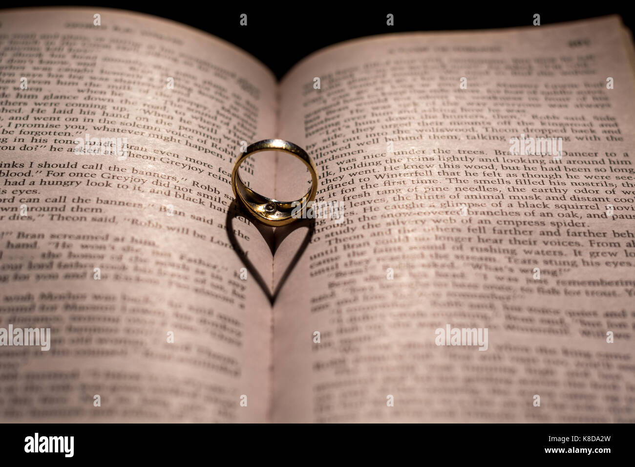 Un cuore fatto da l'ombra di un anello su un libro vicino fino Foto stock -  Alamy
