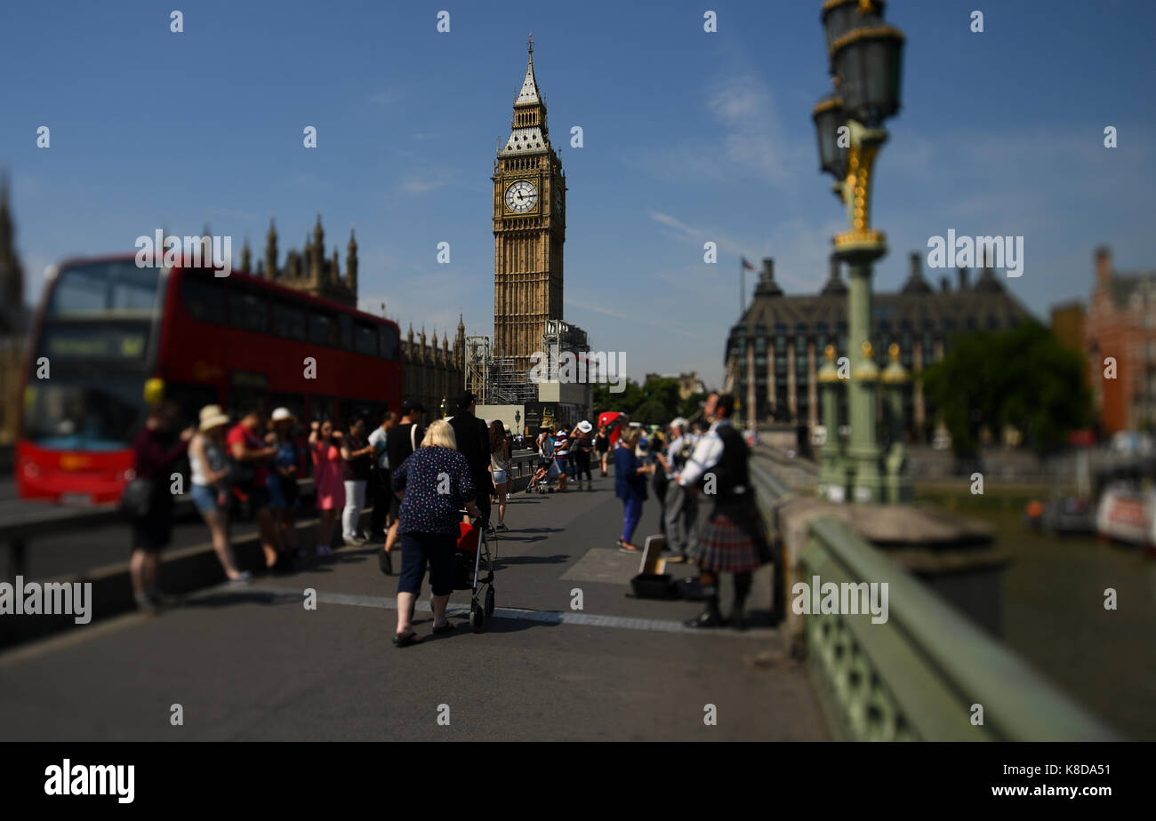 Un turista occupato riempito Westminster Bridge post barriere protettive con il Big Ben e la torre di Elizabeth guardando in giù con tilt shift effetto lente Foto Stock