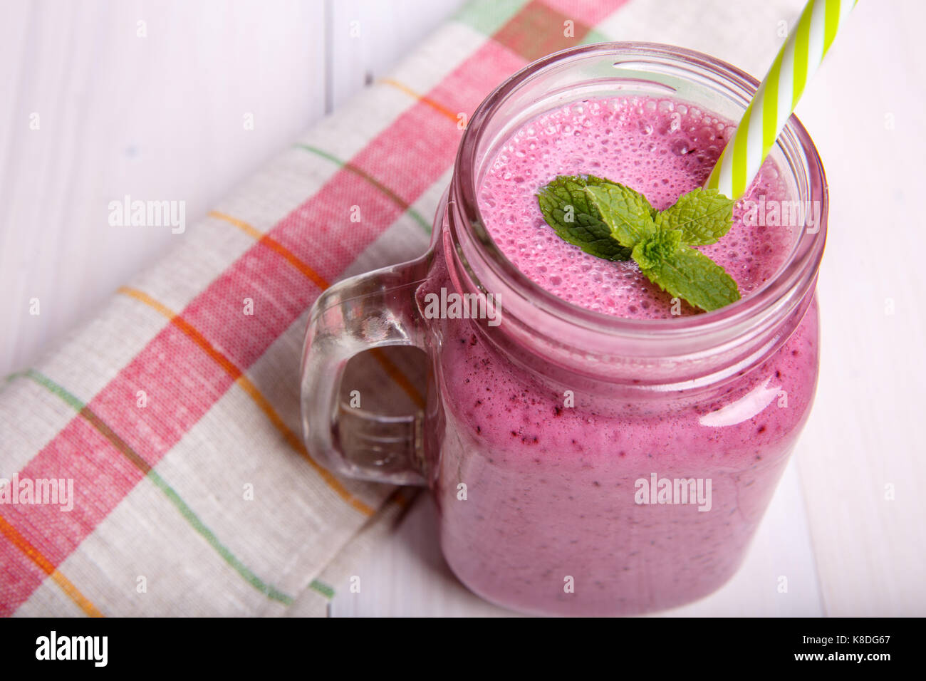 Frullato di frutti di bosco o smoothie con ingredienti e menta. bibita salutare a mason jar. Foto Stock