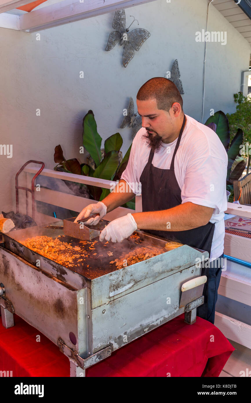 Uomo ispanico, Cook, la cottura sulla sommità piana grill, cuocere carne, grigliare carni, piastra, party in piscina, Castro Valley, contea di Alameda, California Foto Stock