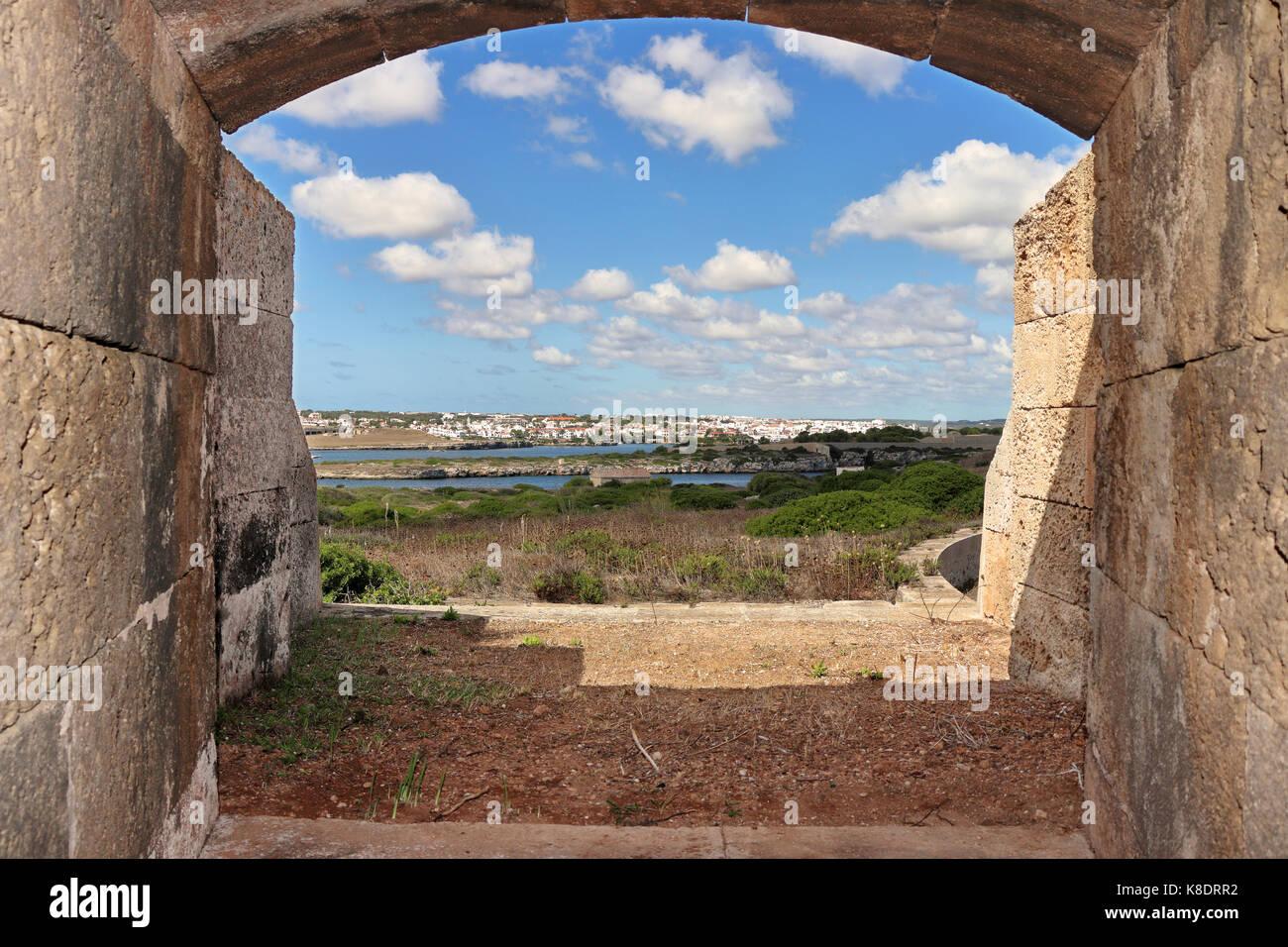 Vista costiera sull isola delle Baleari di Minorca nel mare mediterraneo presi da un vecchio difensivo di apertura della pistola con la città di mahon attraverso l'estuario Foto Stock