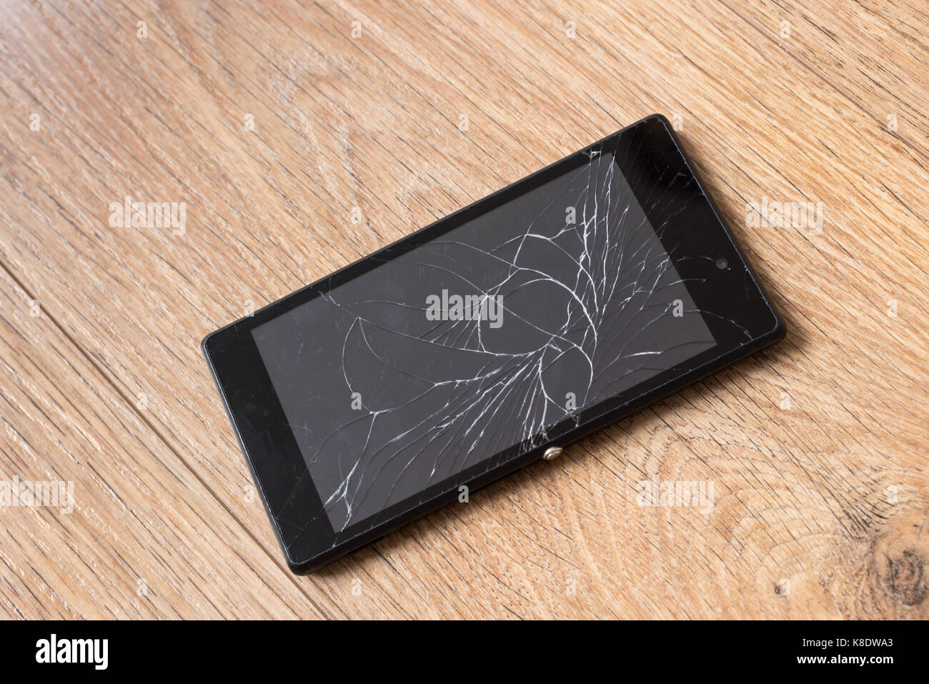 Smartphone rotto, su sfondo di legno Foto Stock