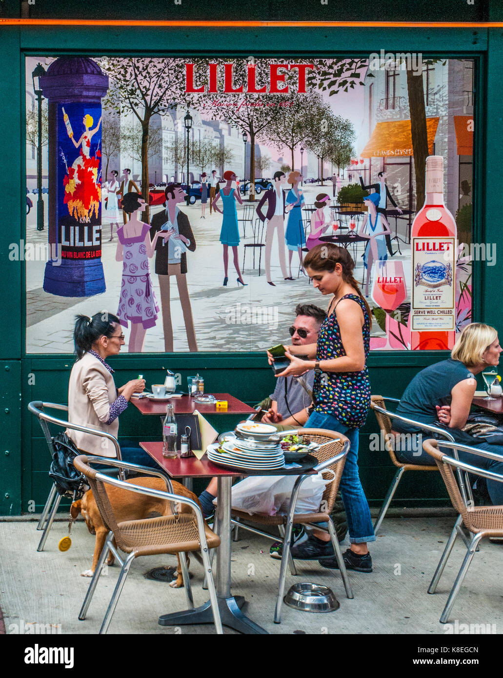 Cameriera di prendere un pranzo di fine da un giovane al naschmarkt mercato domenicale, Vienna, Austria, contro lo sfondo di un grande cartellone pubblicitario Foto Stock
