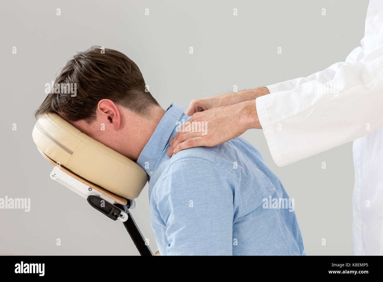 L'uomo avente una terapia in poltrona di massaggio in ufficio business Foto Stock
