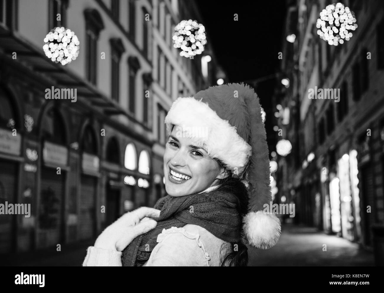 Viaggio pieno di ispirazione al tempo di Natale a Firenze. ritratto di felice donna moderna nel cappello di Natale A Natale a Firenze, Italia Foto Stock