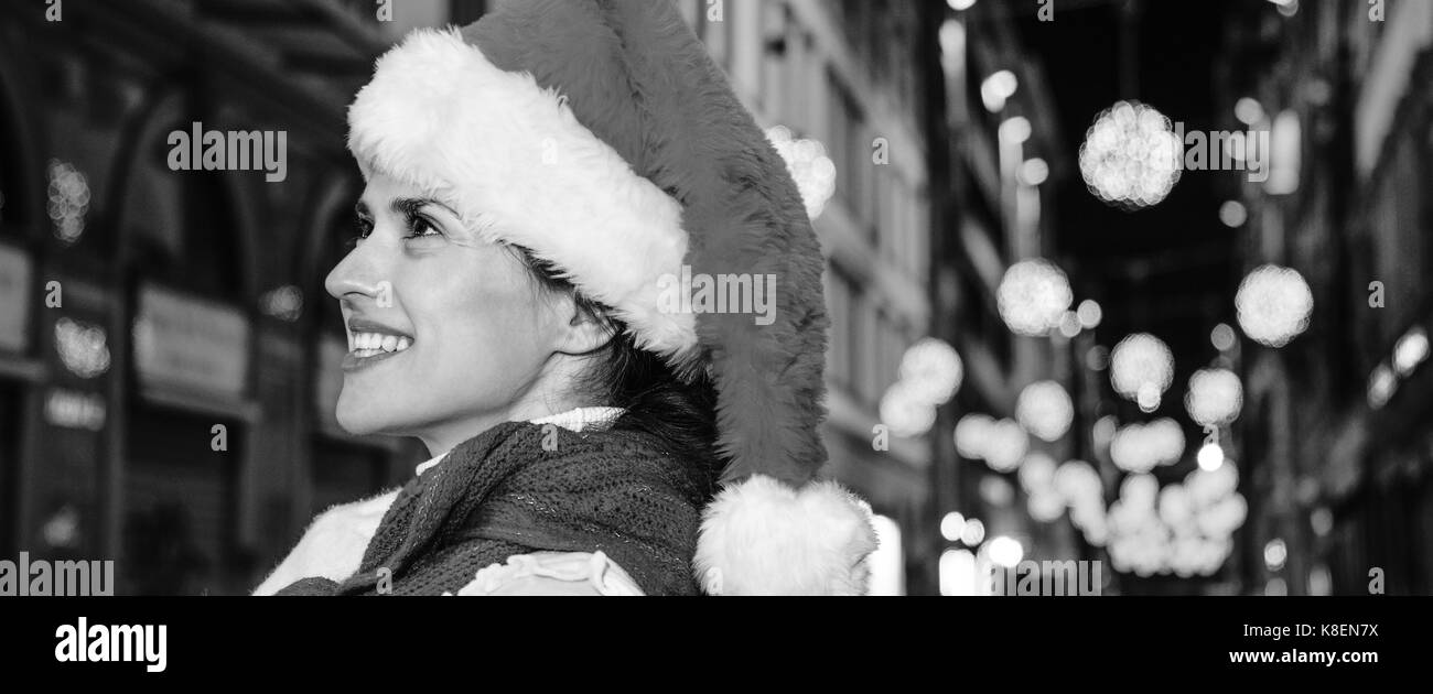 Viaggio pieno di ispirazione al tempo di Natale a Firenze. ritratto di felice donna moderna nel cappello di Natale A Natale a Firenze, Italia Foto Stock