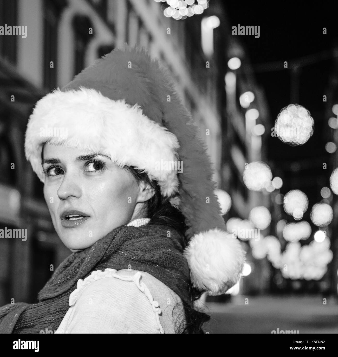 Viaggio pieno di ispirazione al tempo di Natale a Firenze. closeup su sorpreso donna moderna nel cappello di Natale A Natale a Firenze, Italia Cercando asi Foto Stock