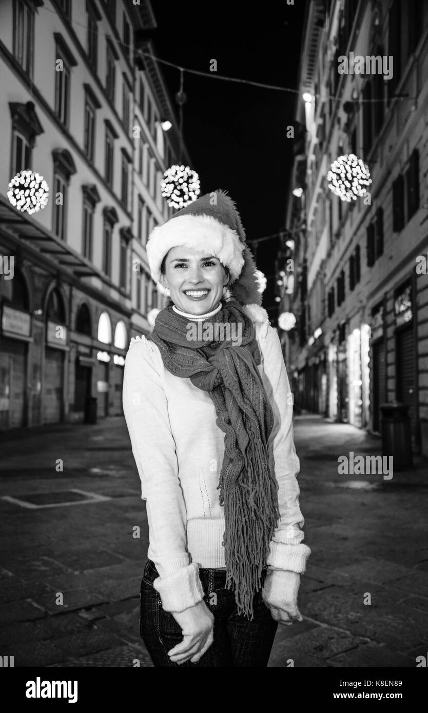 Viaggio pieno di ispirazione al tempo di Natale a Firenze. ritratto di felice donna moderna nel cappello di Natale A Natale a Firenze, Italia Foto Stock