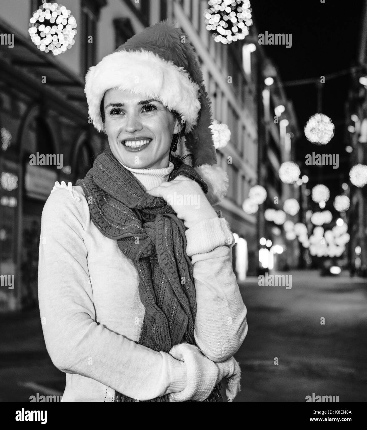 Viaggio pieno di ispirazione al tempo di Natale a Firenze. ritratto di felice donna moderna nel cappello di Natale A Natale a Firenze, Italia cercando in t Foto Stock