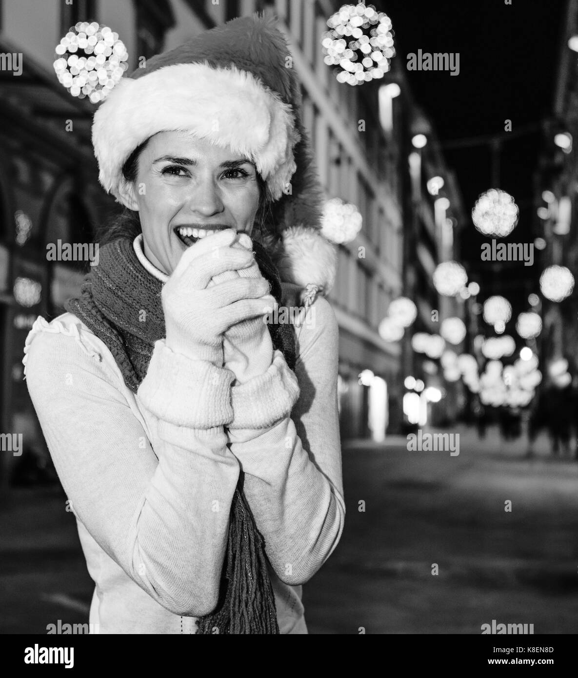 Viaggio pieno di ispirazione al tempo di Natale a Firenze. ritratto di felice donna moderna nel cappello di Natale A Natale a Firenze, Italia mani di riscaldamento Foto Stock