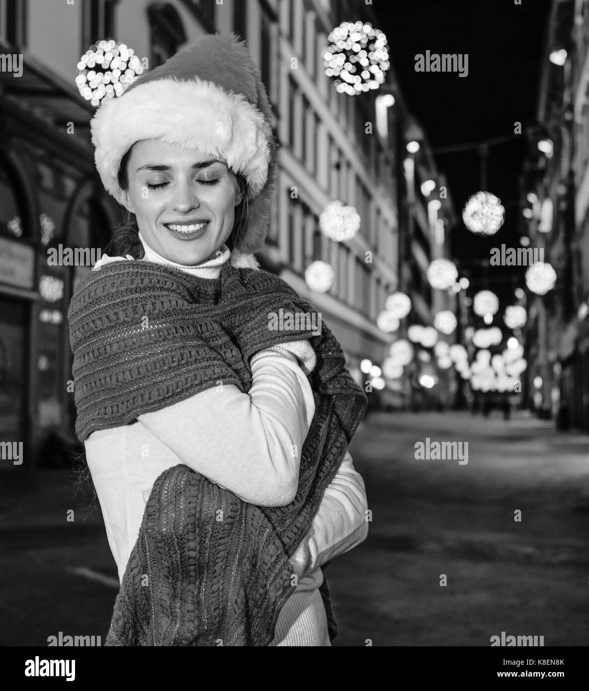 Viaggio pieno di ispirazione al tempo di Natale a Firenze. ritratto di sorridente giovane donna nel cappello di Natale A Natale a Firenze, Italia wrap-up per i Foto Stock