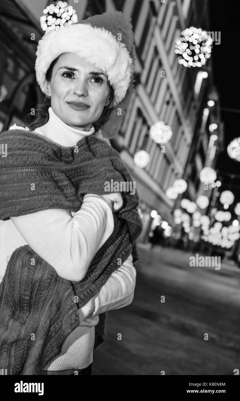 Viaggio pieno di ispirazione al tempo di Natale a Firenze. ritratto di sorridente giovane donna nel cappello di Natale A Natale a Firenze, Italia cercando in Foto Stock