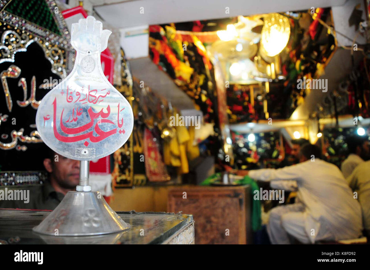 Negoziante vende oggetti sacri utilizzati in azadari per muharram- ul-haram proveniente in anticipo, presso il suo negozio a Rawalpindi il lunedì, 18 settembre 2017. Foto Stock