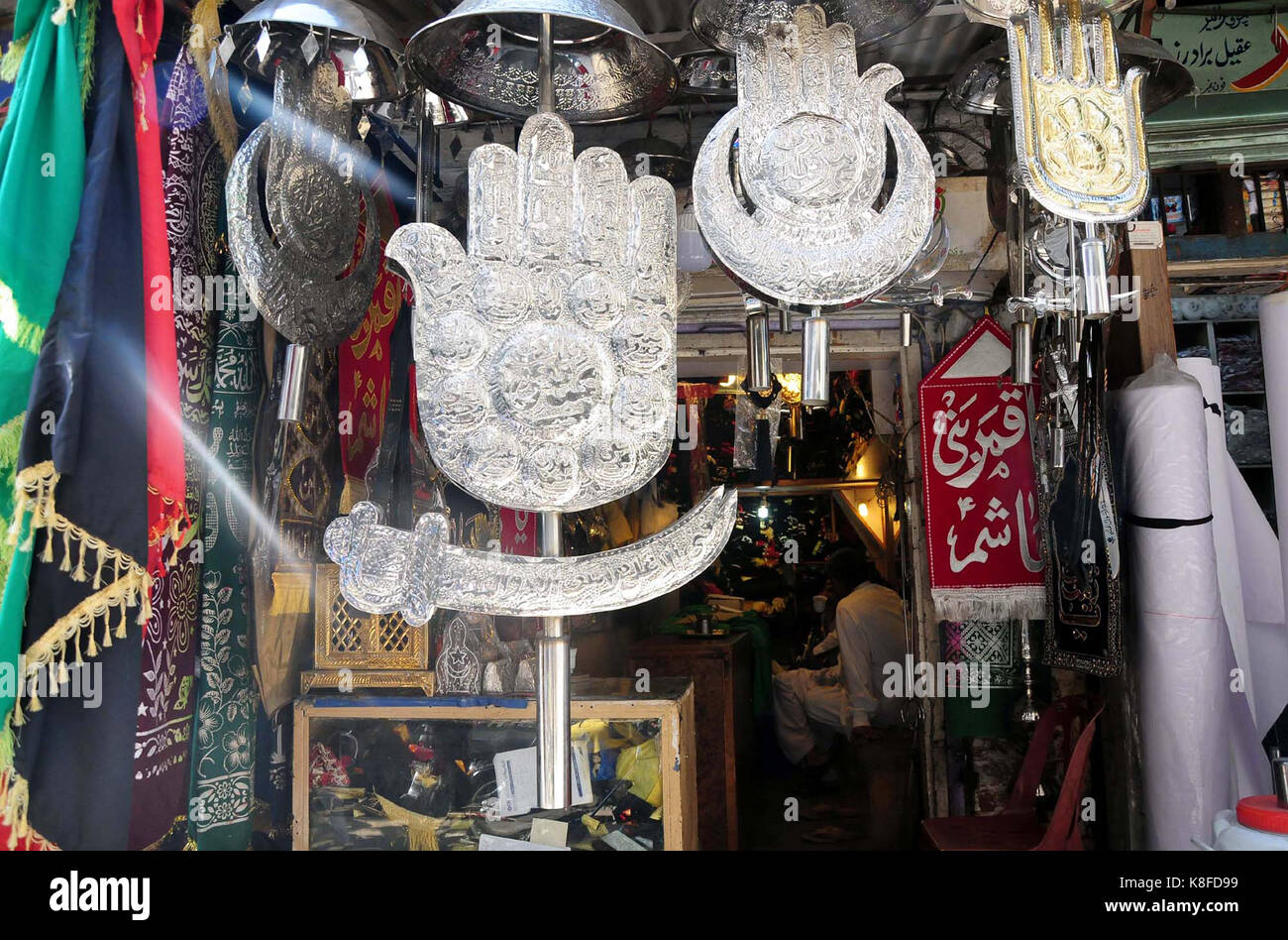 Negoziante vende oggetti sacri utilizzati in azadari per muharram- ul-haram proveniente in anticipo, presso il suo negozio a Rawalpindi il lunedì, 18 settembre 2017. Foto Stock