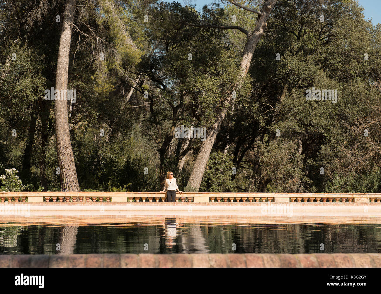 Turista femminile guardando lateralmente dal lago nel parco a labirinto di Horta, Barcellona, Spagna Foto Stock