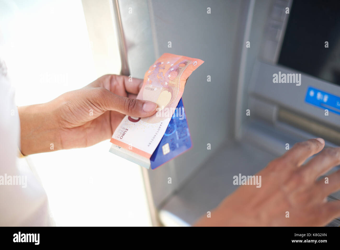 Donna che utilizza cash dispenser Foto Stock