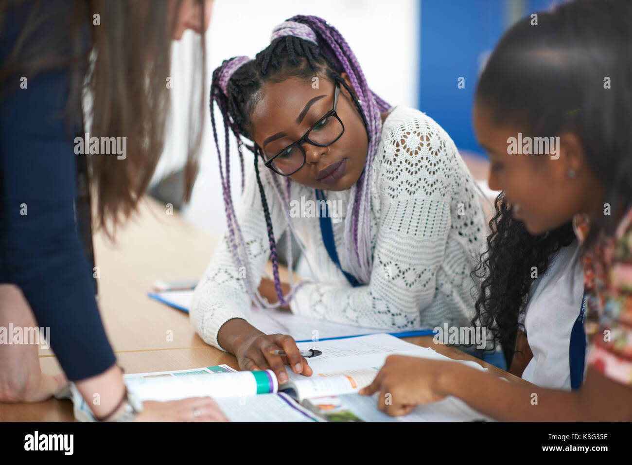 Insegnante in classe aiuta gli studenti a studiare Foto Stock