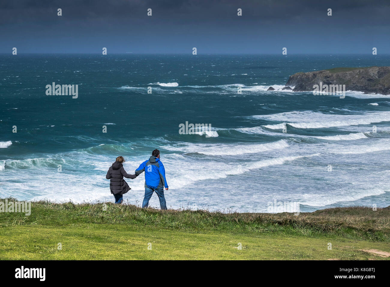 Tregurrian - un paio di camminare mano nella mano sulla cima di una scogliera percorso in corrispondenza di Bedruthan Steps sulla North Cornwall coast. Foto Stock