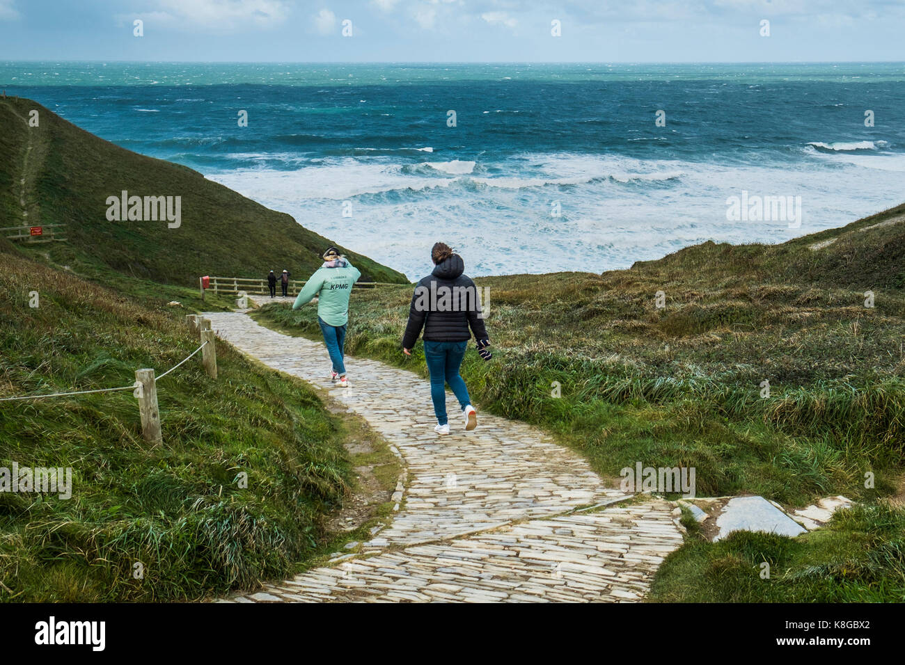 Tregurrian - persone che camminano giù il sentiero costiero di Bedruthan Steps sulla North Cornwall coast. Foto Stock