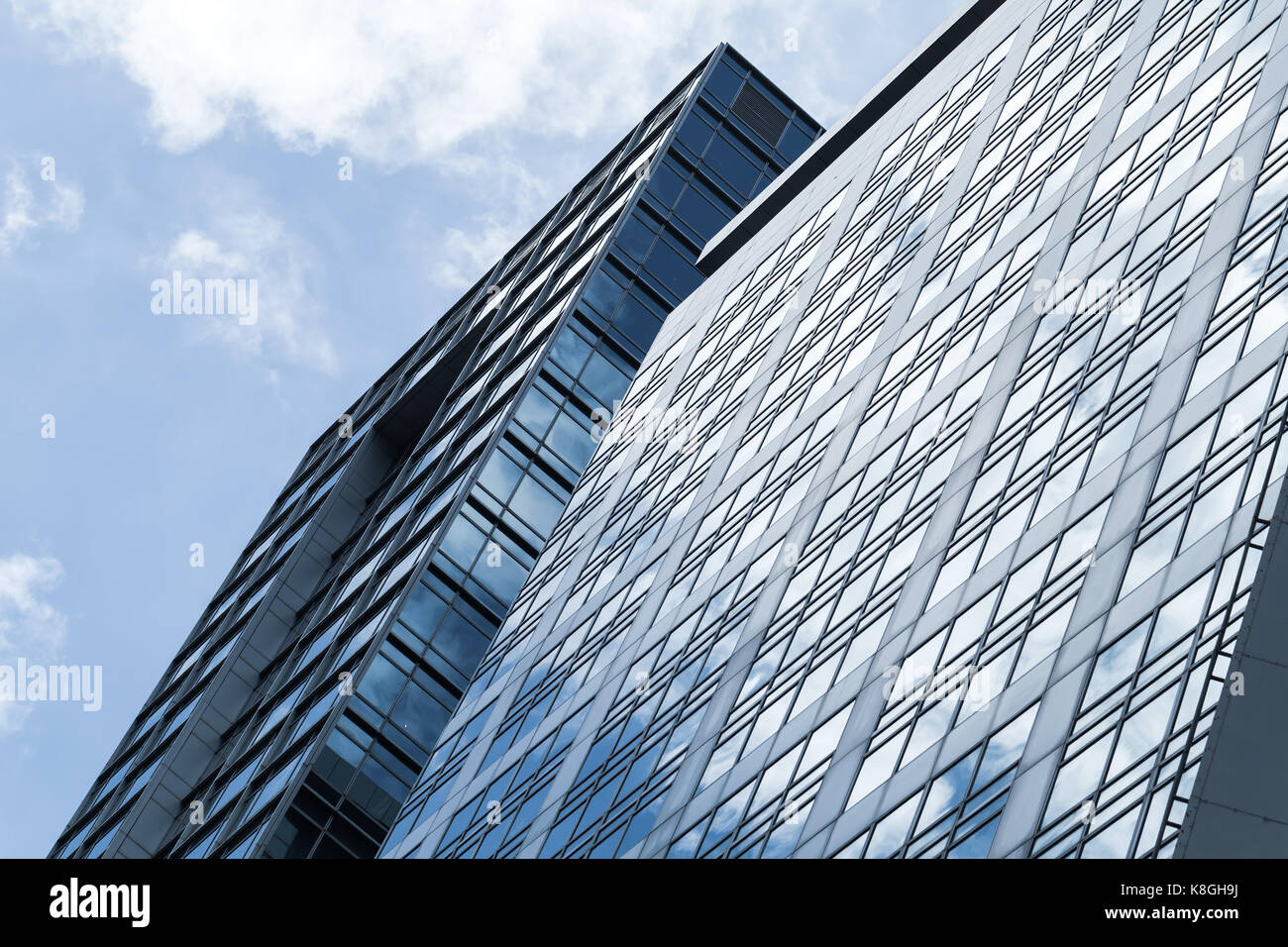 Abstract architettura moderna sfondo, ufficio torre di vetro e acciaio con riflessi di cielo nuvoloso Foto Stock