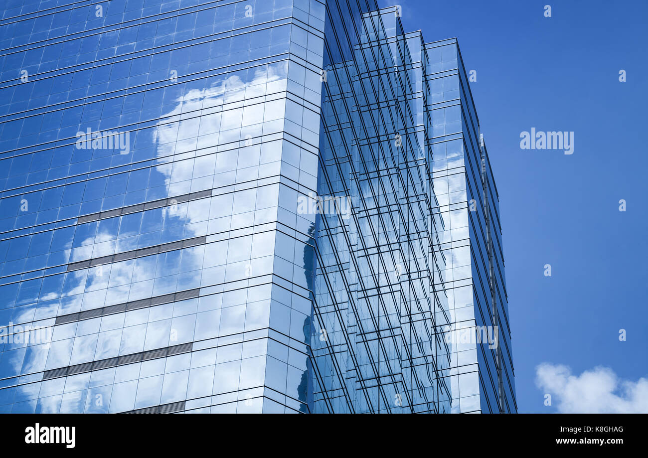 Abstract architettura moderna sfondo, torre di uffici realizzati in vetro blu e acciaio con riflessi di cielo nuvoloso Foto Stock