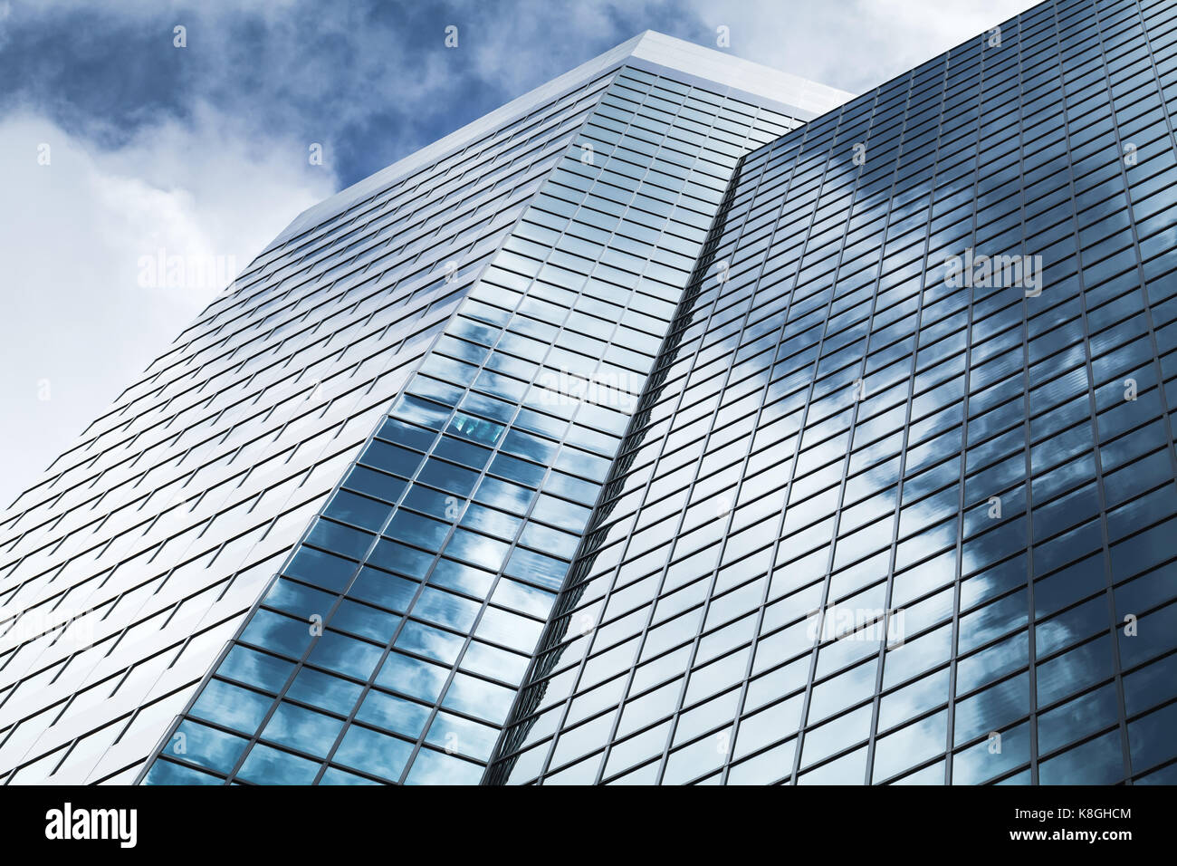 Abstract architettura moderna fotografia di sfondo, ufficio torre realizzata in vetro blu e acciaio con riflessi di cielo nuvoloso Foto Stock