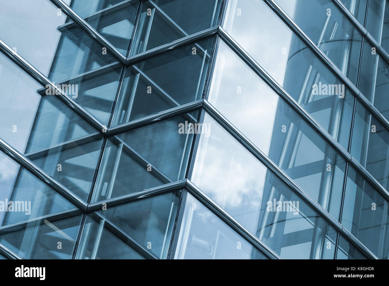 Frammento astratto di architettura contemporanea, le pareti in vetro e acciaio con riflessi di cielo nuvoloso Foto Stock