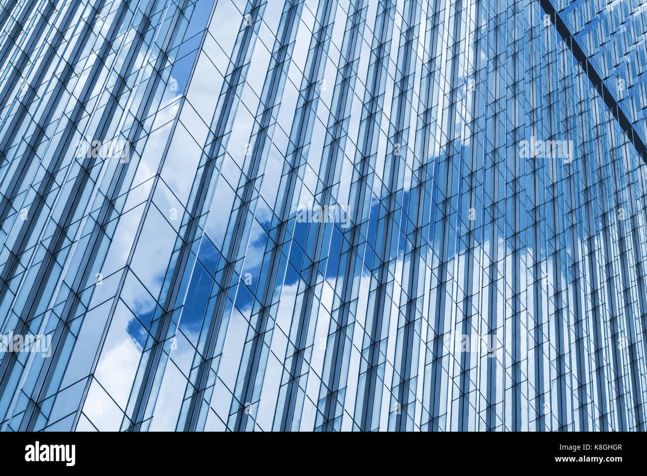 Frammento astratto di architettura moderna, le pareti in vetro e acciaio con riflessi di cielo nuvoloso Foto Stock