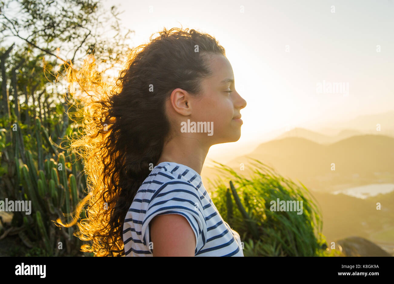La ragazza con gli occhi chiusi durante il tramonto, Rio de Janeiro, Brasile Foto Stock