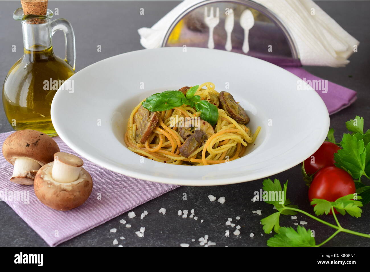 Pasta con funghi e pesto in una piastra bianca su sfondo astratto. Lo stile di vita italiano. il mangiare sano concetto Foto Stock